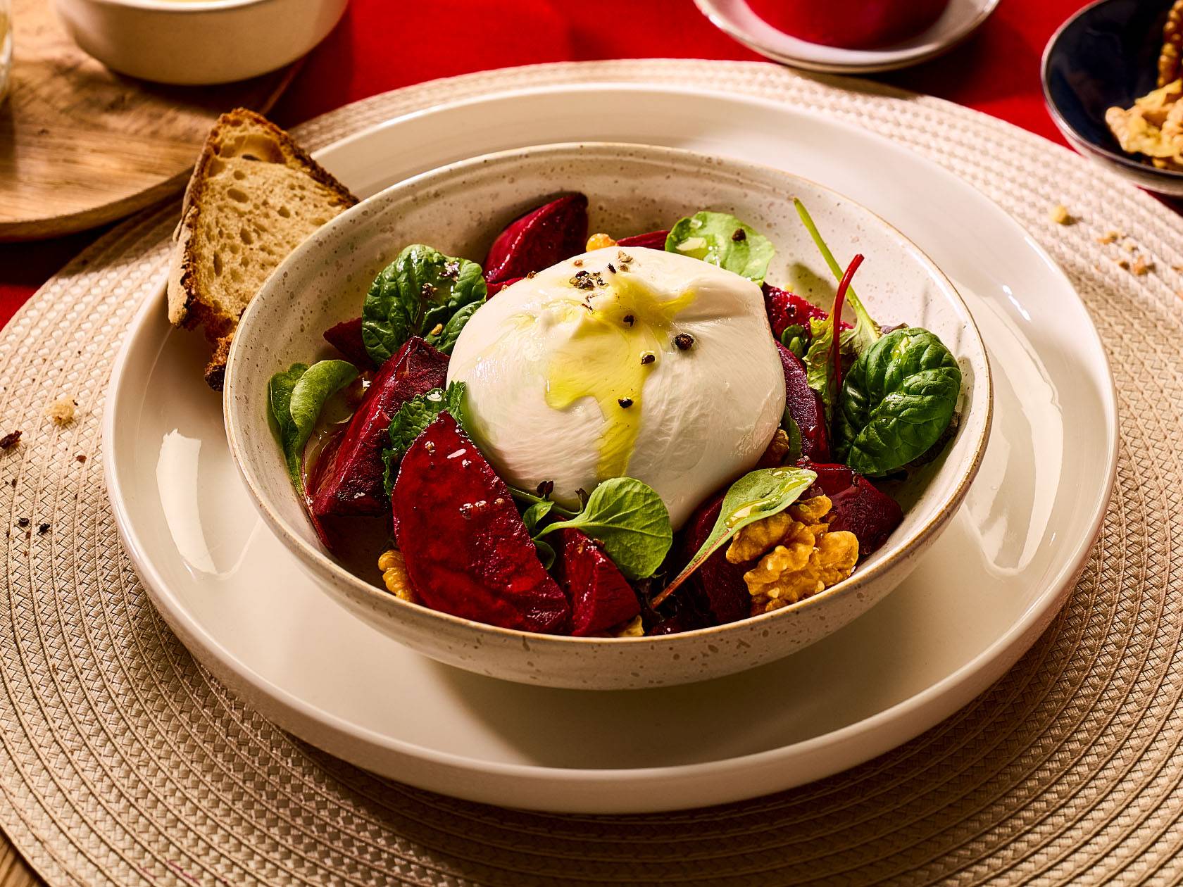 Burrata siers ar bietēm, valriekstiem un salātiem bļodā uz galda.