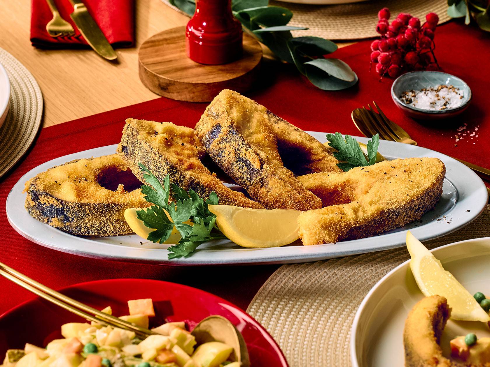 Cepta zivs ar citronu un pētersīļiem uz svētku galda.