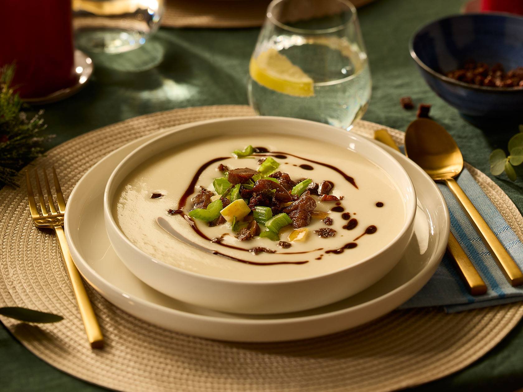 Krēmzupa ar gaļas gabaliņiem un zaļumiem uz svētku galda